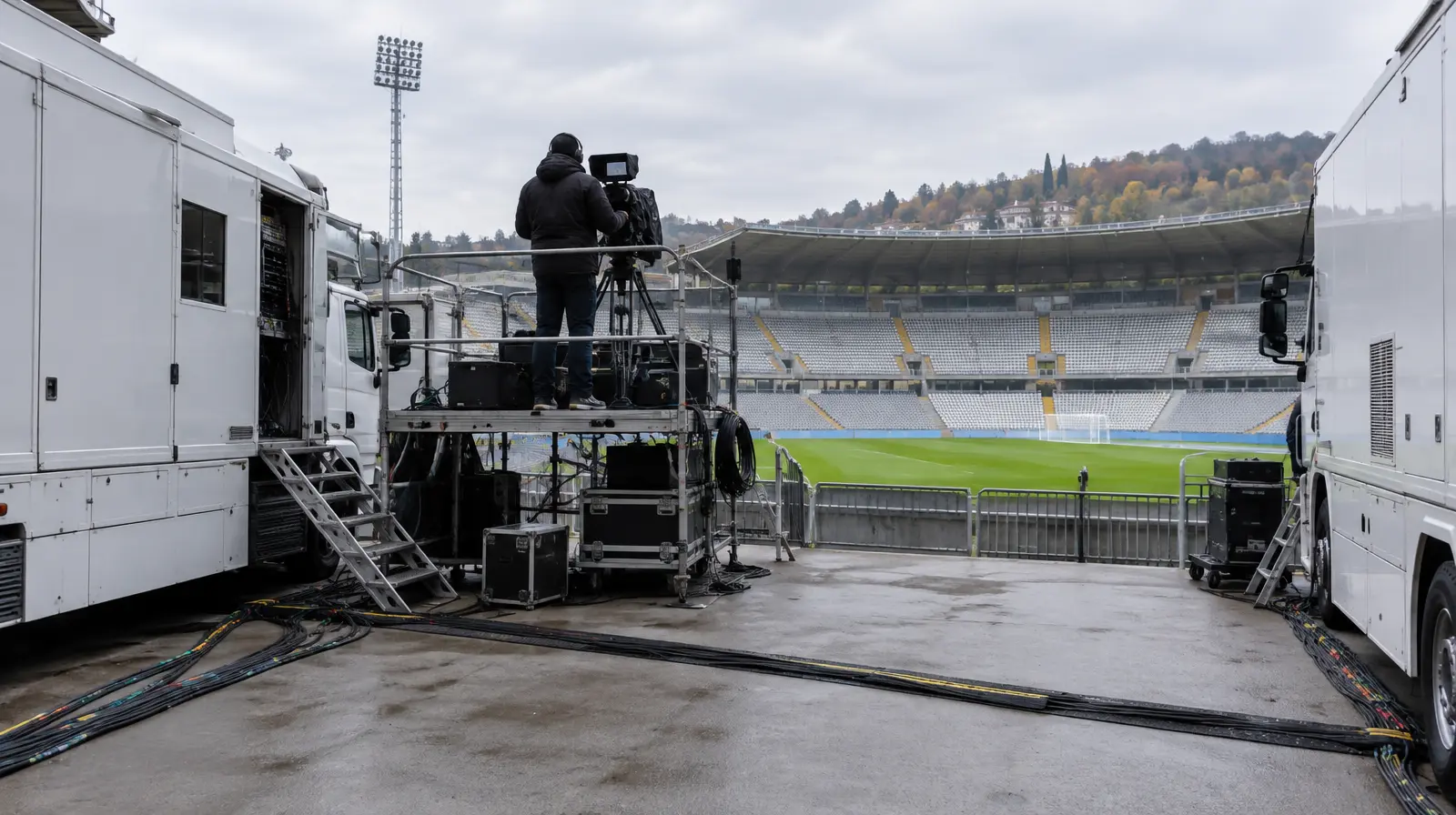 Tv-utrustning och kameraoperatör utanför en fotbollsarena inför sändning